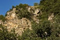 Panorama with high vertical limestone rocks and niches, ruins of former rock monastery